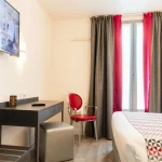 Chambre Double Classique de l’Hôtel Versailles Chantiers avec bureau, télévision murale et fenêtre avec rideaux