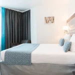 Chambre Triple Supérieure à l’Hôtel Versailles Chantiers avec grand lit double et espace lumineux