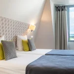 Chambre Twin Supérieure à l’Hôtel Versailles Chantiers avec lits jumeaux et tête de lit capitonnée